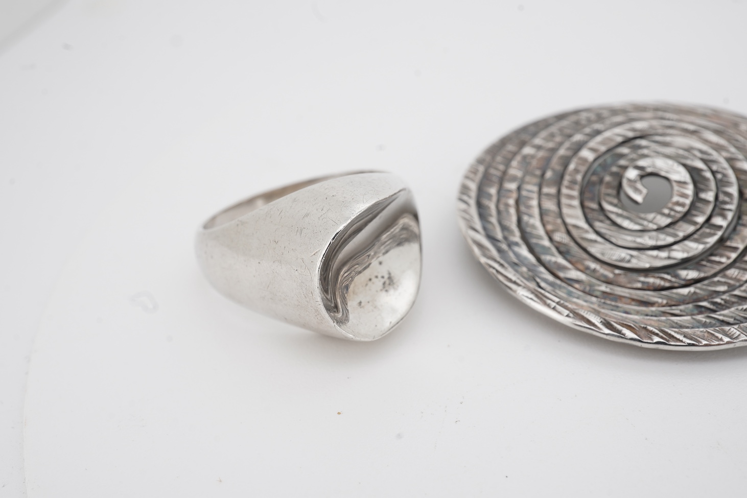 A mid to late 20th century Danish sterling tri-form brooch and a 925S ring by by Carl Ove Frydensberg, brooch, 43mm and a 1970's Finnish 925 circular brooch, by Kuppittaan Kulta, Turku, diameter 36mm.